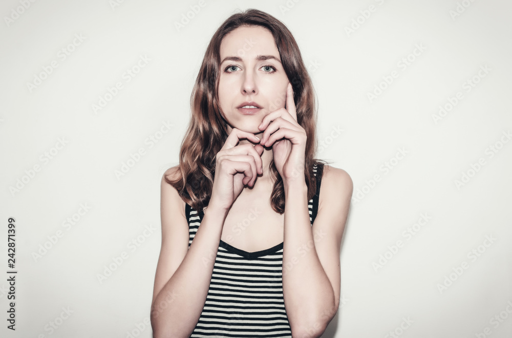 Nice girl in a striped T-shirt. Hands near face