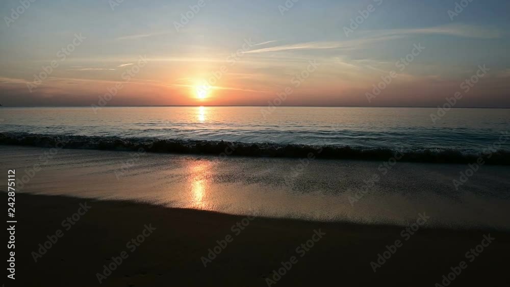 Slow motion of waves breaking on sandy beach in sunset Slow motion of waves breaking on sandy beach in sunset