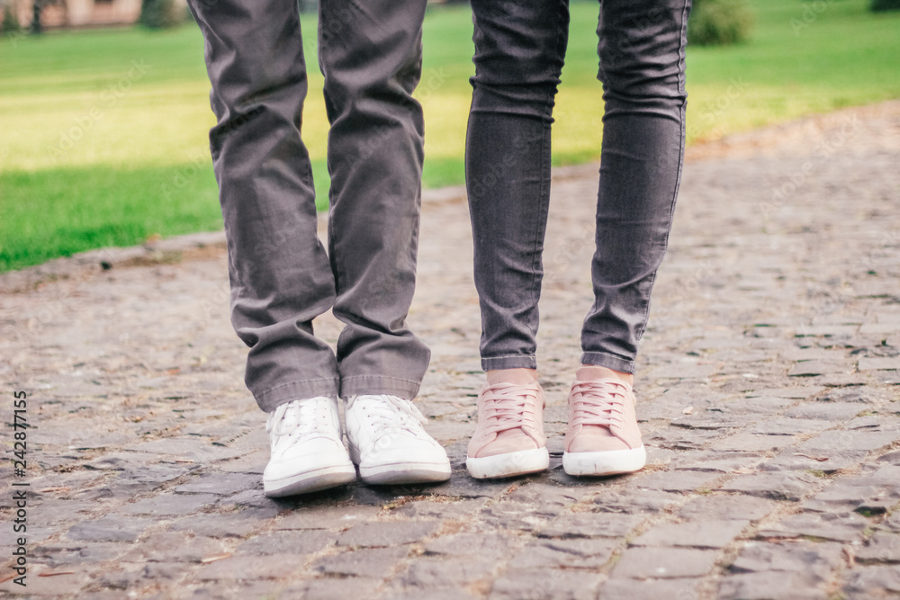 legs of a loving couple in sneakers