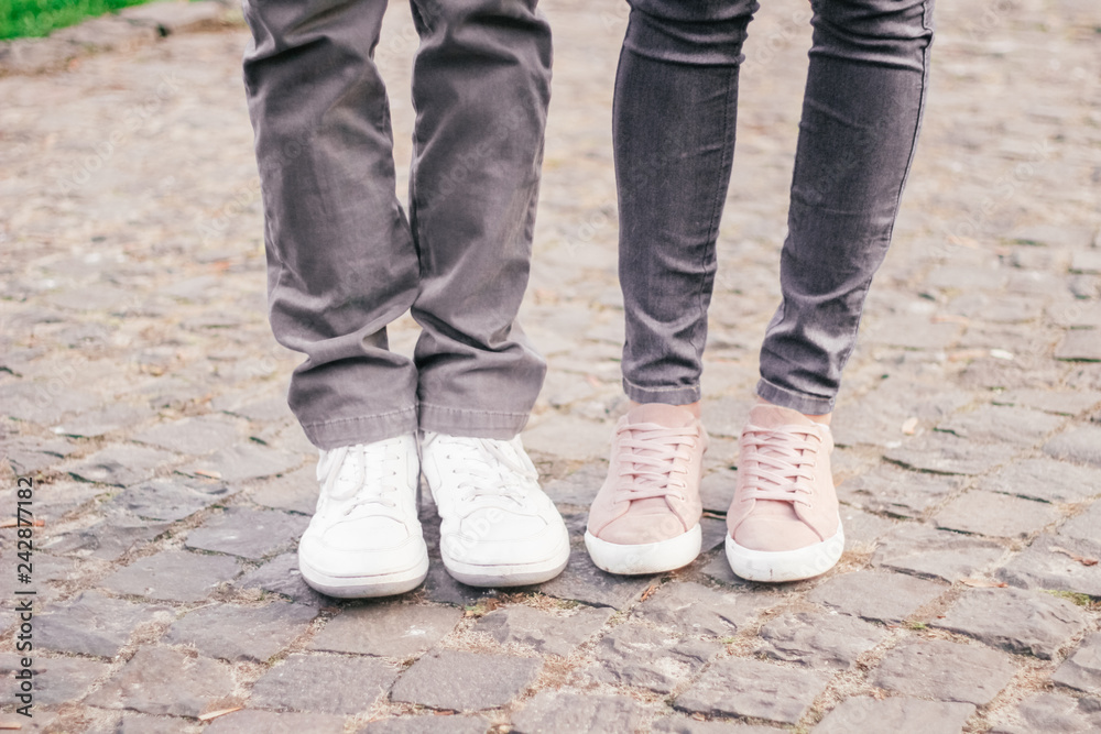 legs of a loving couple in sneakers