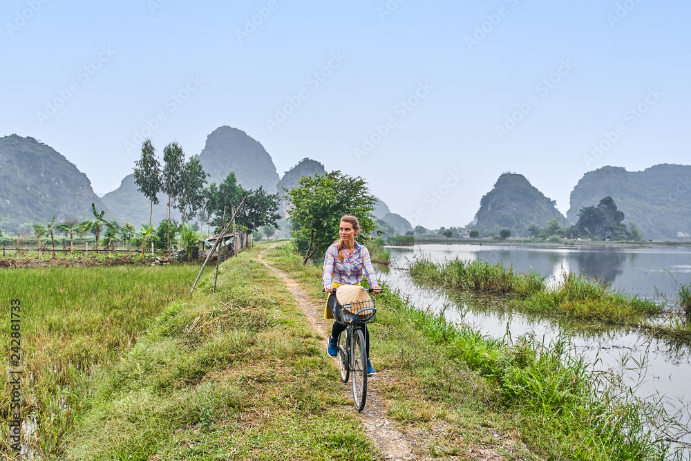 Beautiful european woman is riding a bike in Vietnamese ha