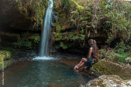 woman sitting next to waterfall