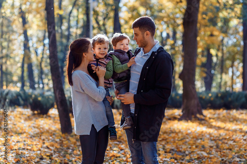 Natural pictures of a happy family of four having fun outsiade on a sunny autumn day. Togetherness and happiness concept