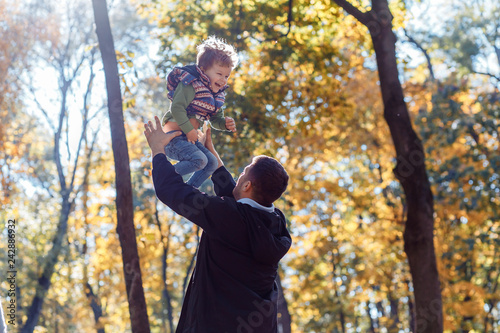 Dad and son playing outside in autumn in the park