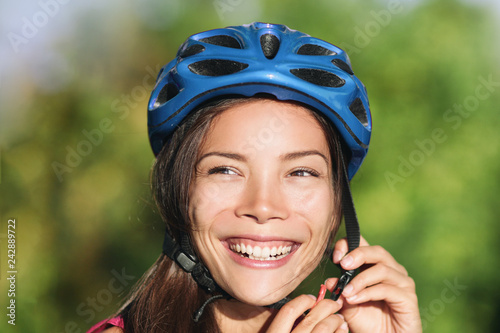 Asian woman wearing bike helmet for biking commute -city cyclist lifestyle. Safety on the road. photo