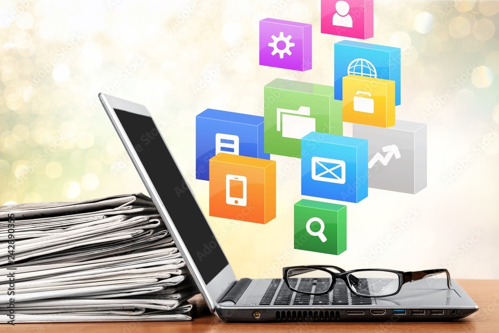 Silver laptop with glasses and heap of papers Silver laptop with glasses and heap of papers
