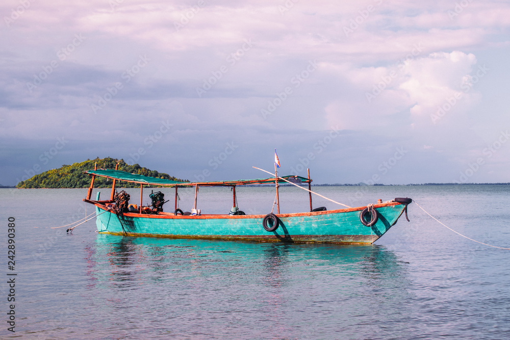 Blue wooden fishing boats in calm tropical turquoise water near Rabbit Island in Cambodia