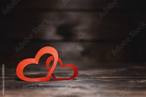 two red paper hearts on a dark background . A gift for a loved one on Valentine s day.