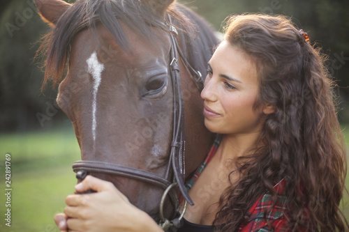 Close up of a pretty girl strocking her horse
