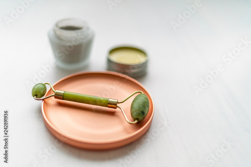 Luxury skincare korean beauty products - creams, balm and mud mask jars with jade stone face roll massager - Facial roller massaging therapy.