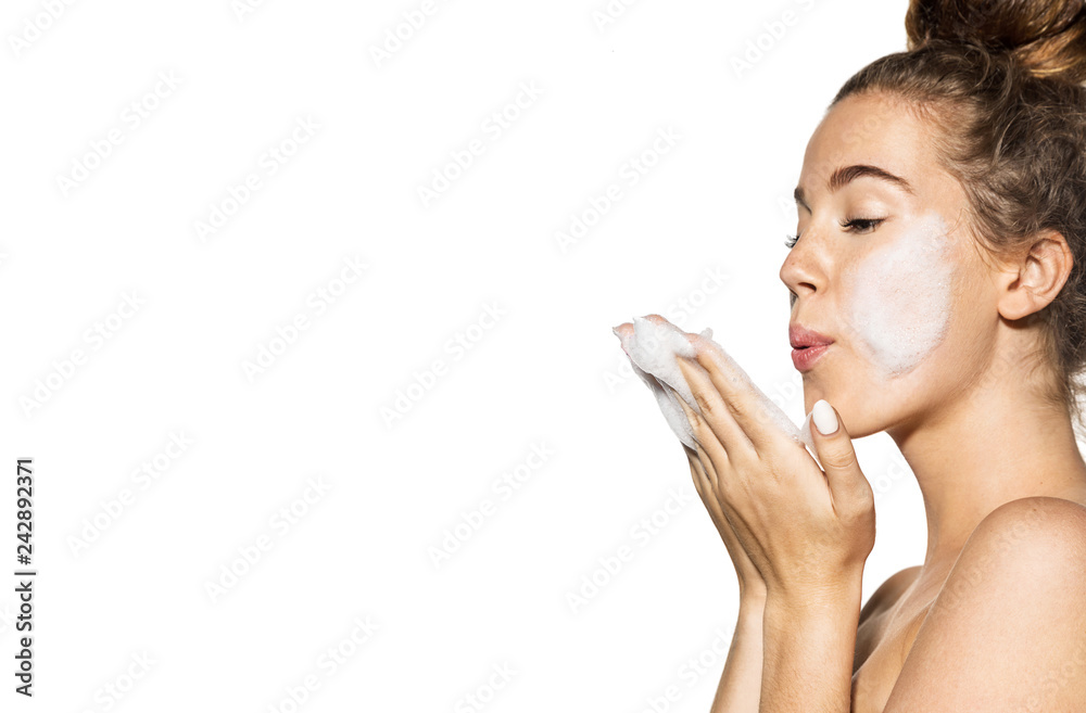 Portrait of cheerful young model blowing foam. Good-looking woman posing with bare shoulders. Wellness youth and skincare concept. Isolated on white background Portrait of cheerful young model blowing foam. Good-looking woman posing with bare shoulders. Wellness youth and skincare concept. Isolated on white background
