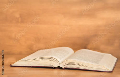Open book on wooden background.
