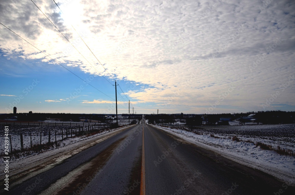 road in winter with blue sky and clouds