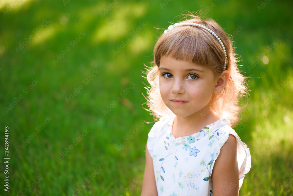 Portrait of a beautiful young little girl in summer park Portrait of a beautiful young little girl in summer park