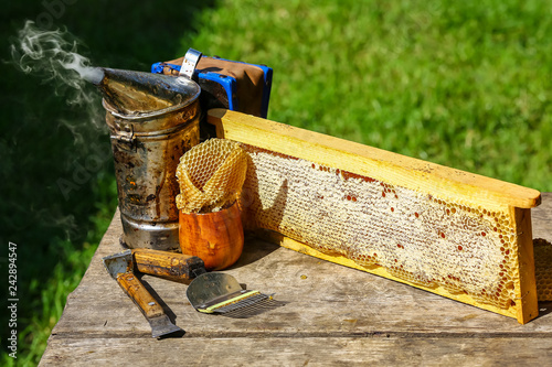 Beekeeper working tools on the hive. beekeeping equipment on a wooden table outdoors with copy space photo
