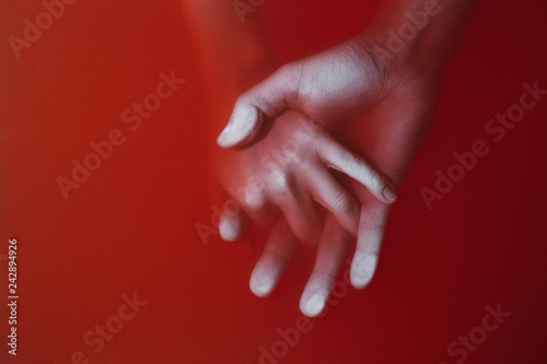 Photos plexus of the hands of a man and a woman drowning in red water similar to blood,