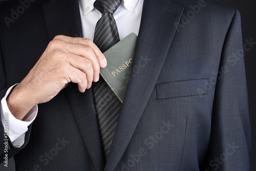 Closeup of a business man taking his passport for his suit jackets inside breast pocket.