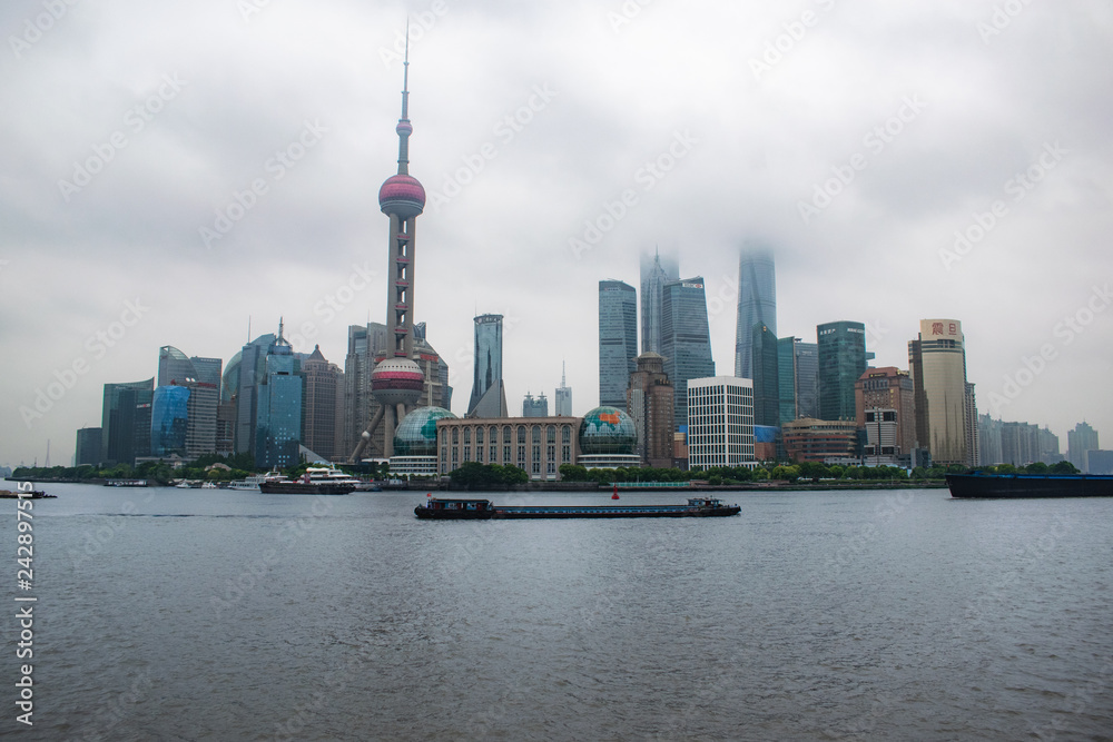 Fototapeta premium Shanghai / China - may 22 2017: Shanghai skyline on a cloudy day with the skyscrapers covered in louds and mist