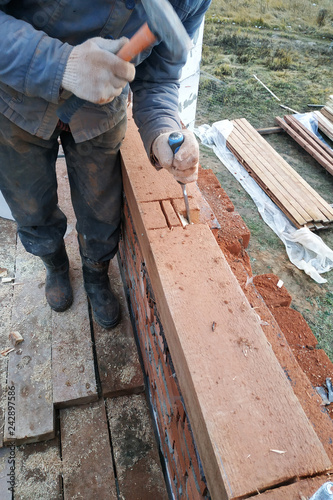 The wizard uses a bit to grind wood in the building