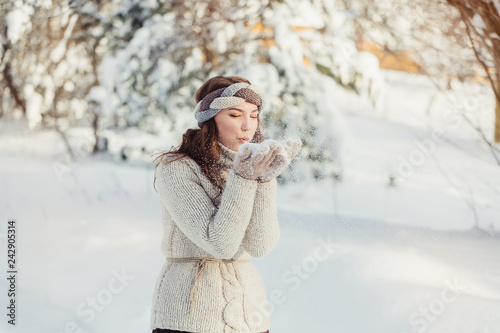 Winter outdoor close up portrait of young pretty cute caucasian girl on showy forest background. Healthy lifestyle concept photo