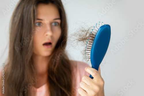 Young woman is upset because of hair loss