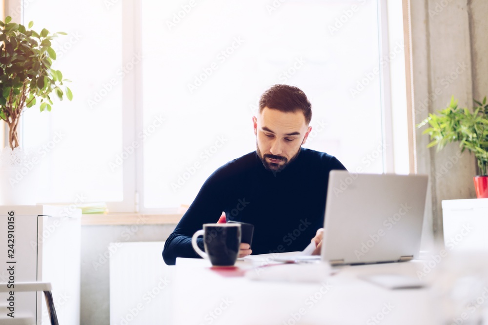 Caucasian young man working on laptop Caucasian young man working on laptop