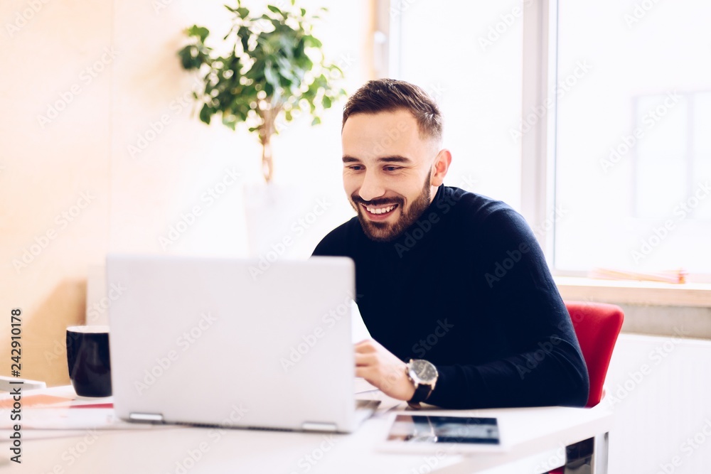 Happy caucasian young man working on laptop computer Happy caucasian young man working on laptop computer