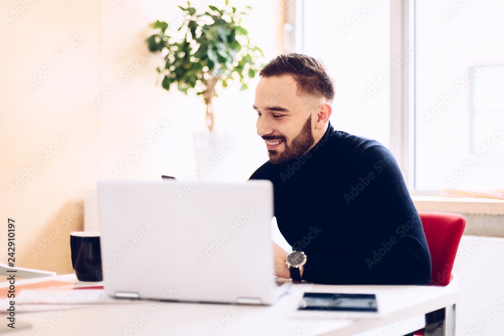 Happy caucasian young man working on laptop computer Happy caucasian young man working on laptop computer