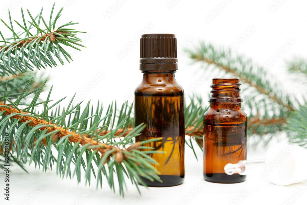 Natural beauty remedy. Small bottle of essential pine oil, pine tree twigs, alternative medicine Natural beauty remedy. Small bottle of essential pine oil, pine tree twigs, alternative medicine