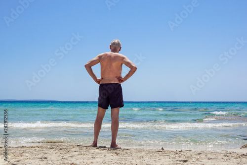 old man lying on the sand at the beach