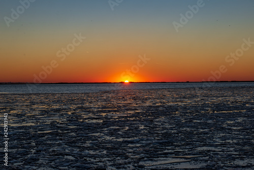 dramatic red sunset over the frozen sea on the beach