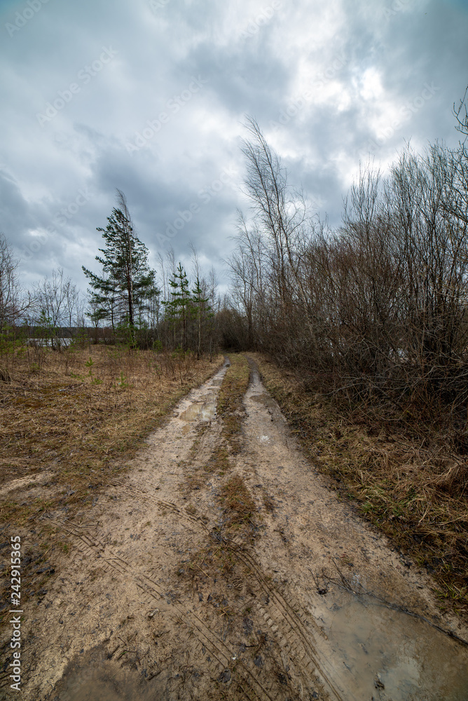 country gravel road with old and broken asphalt country gravel road with old and broken asphalt
