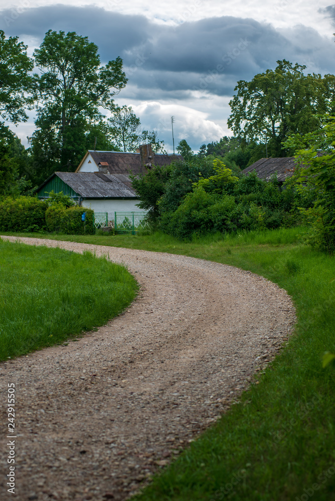 country gravel road with old and broken asphalt country gravel road with old and broken asphalt