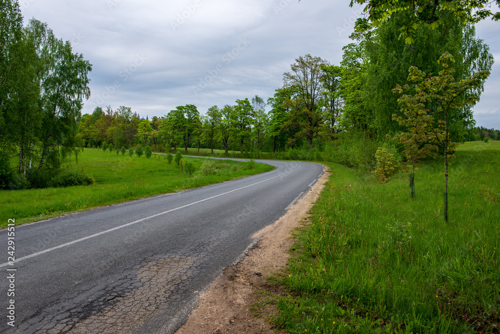 country gravel road with old and broken asphalt country gravel road with old and broken asphalt