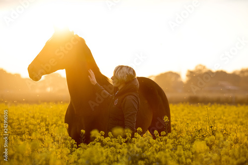 Reiterin lobt Pferd auf dem Feld photo