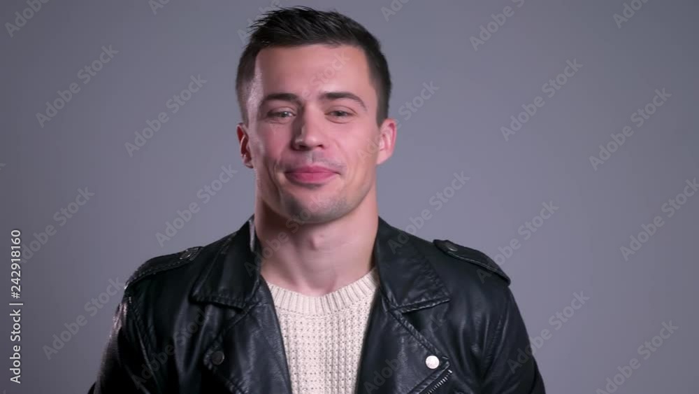 Closeup portrait of charming caucasian man smiling looking at camera and listening to conversation with a little confusion Closeup portrait of charming caucasian man smiling looking at camera and listening to conversation with a little confusion