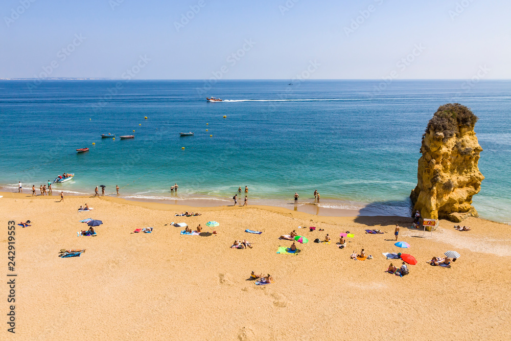 Fototapeta premium Praia da Dona Ana beach, Lagos, Algarve region, Portugal. Praia Dona Ana surrounded by steep colourful strata cliffs. One of the most picturesque beaches in Algarve. One of the best beach of Portugal