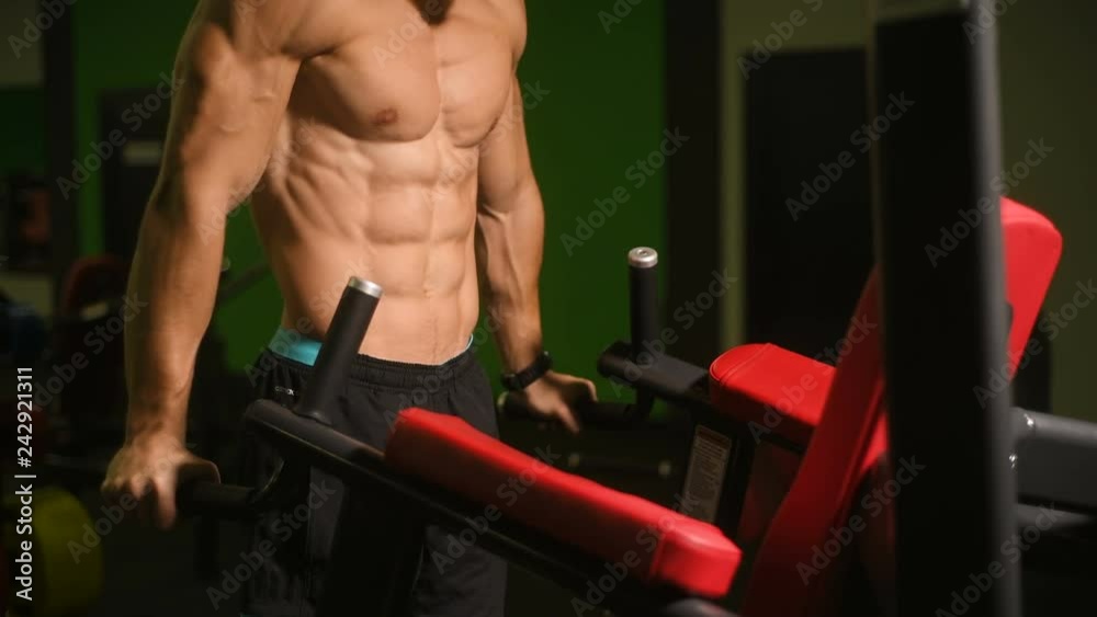 Handsome athletic men pumping up muscles push-ups on uneven bars ...