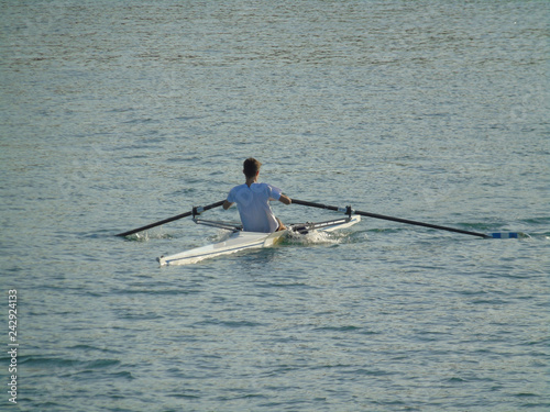 Giovane atleta canoista mentre si allena con la sua canoa in mare aperto