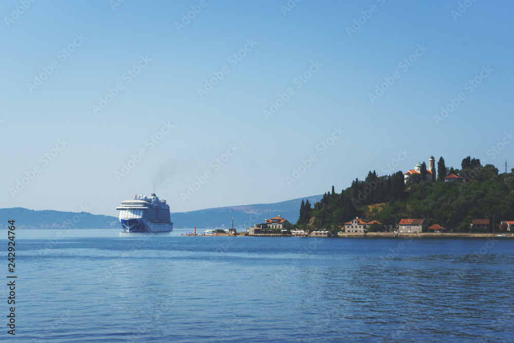 White passenger liner in the bay. Montenegro, Boka Kotorska bay on a hot summer day.