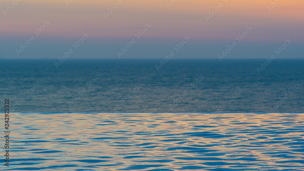 Fototapeta premium infinity swimming pool with ocean background