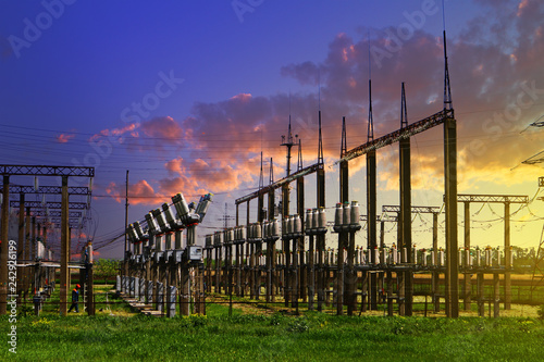 High voltage electric power station - electric poles and lines on blue sunset cloudy sky background