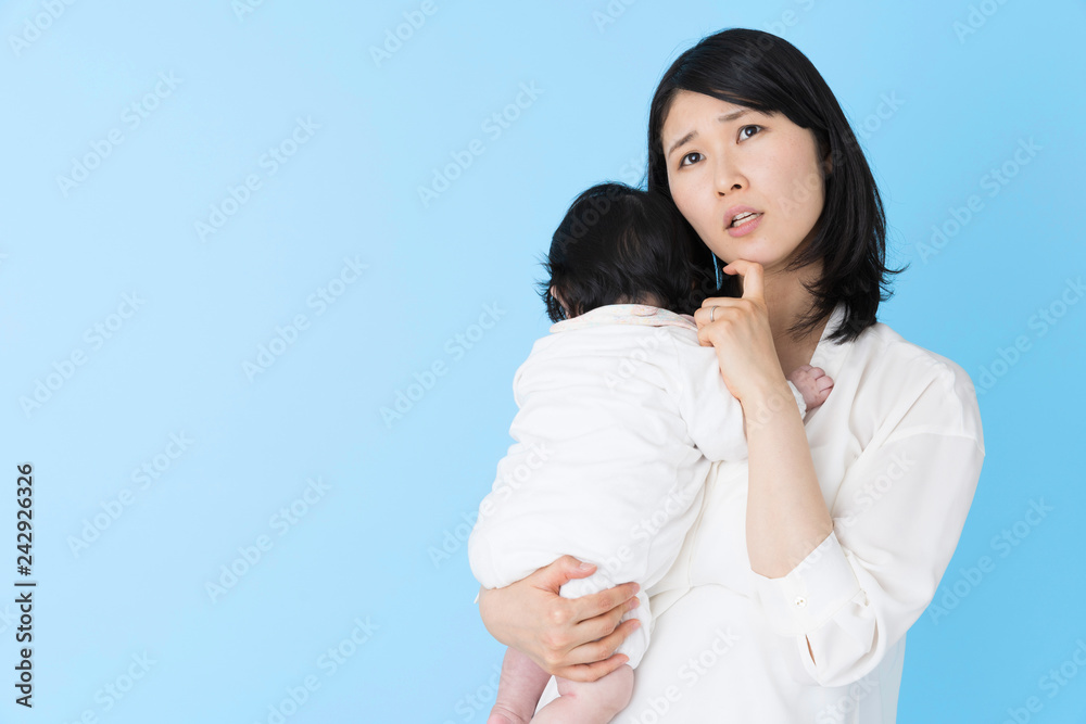 portrait of young asian mother and baby on blue background portrait of young asian mother and baby on blue background