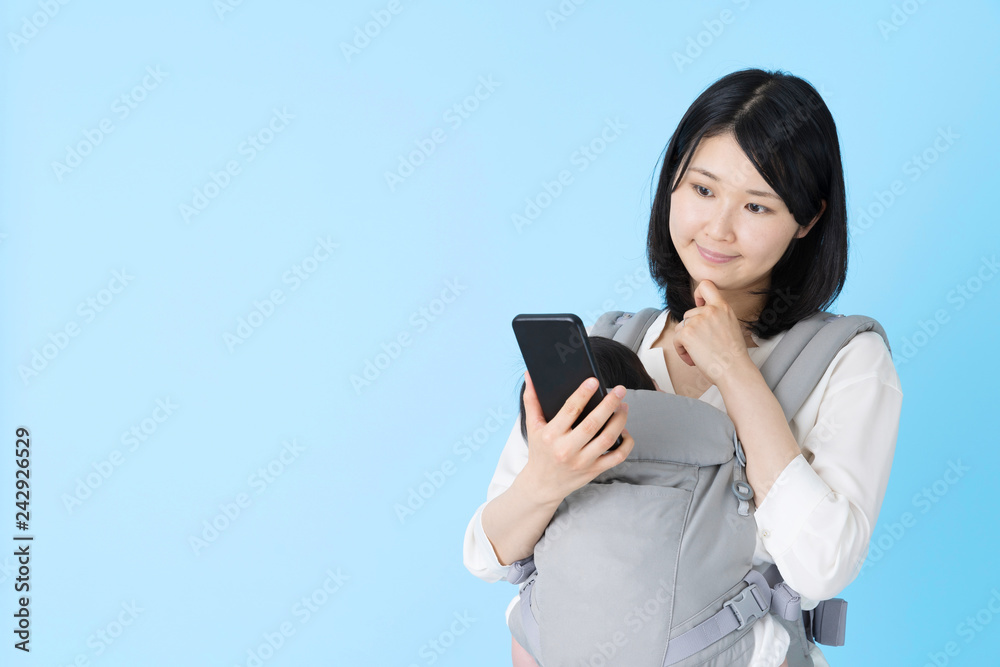portrait of young asian mother and baby on blue background portrait of young asian mother and baby on blue background