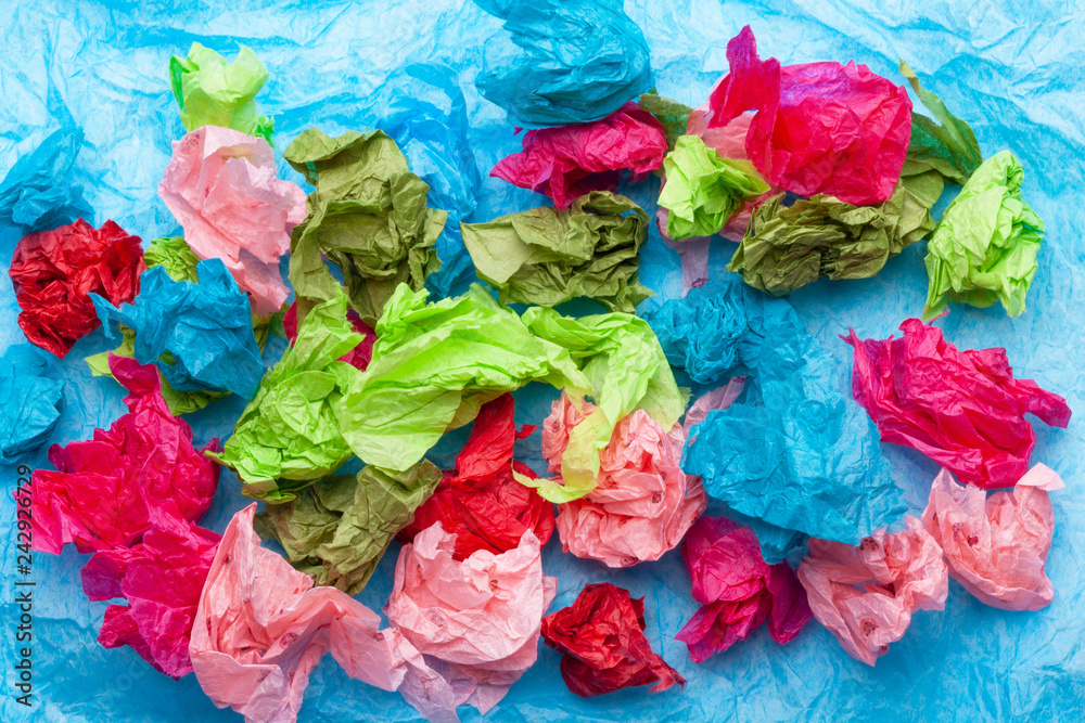 Crumpled colorful tissue paper on a blue tissue paper background Crumpled colorful tissue paper on a blue tissue paper background