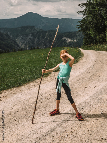 Portrait of girl with stick standing on trail