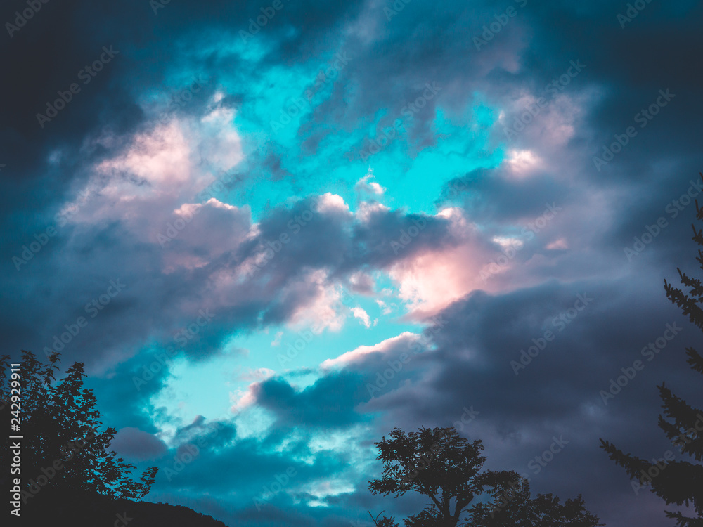 Background of clouds and light blue sky with tree silhouette on foreground. Background of clouds and light blue sky with tree silhouette on foreground.