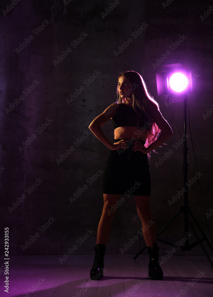 Beautiful sexy blonde woman posing in blue and pink neon light in fashion leather bra Beautiful sexy blonde woman posing in blue and pink neon light in fashion leather bra