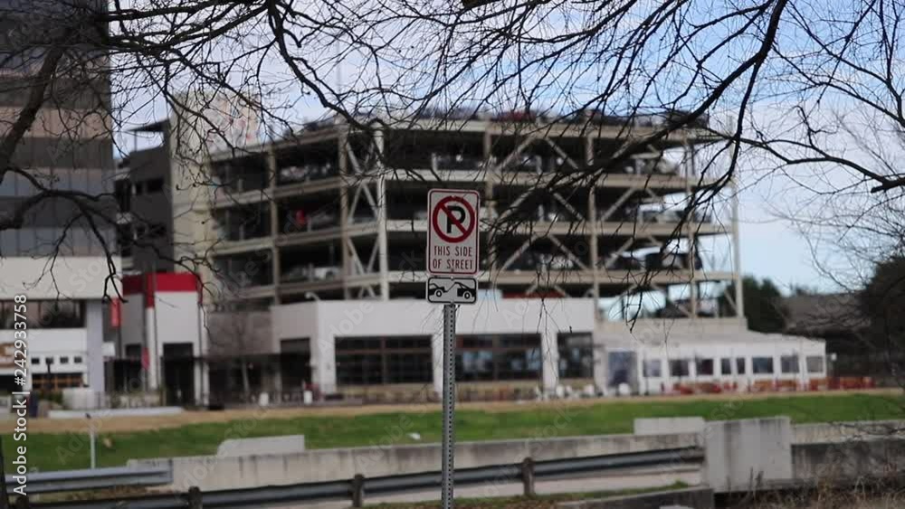 No Parking Sign with Parking Garage in the Background No Parking Sign with Parking Garage in the Background