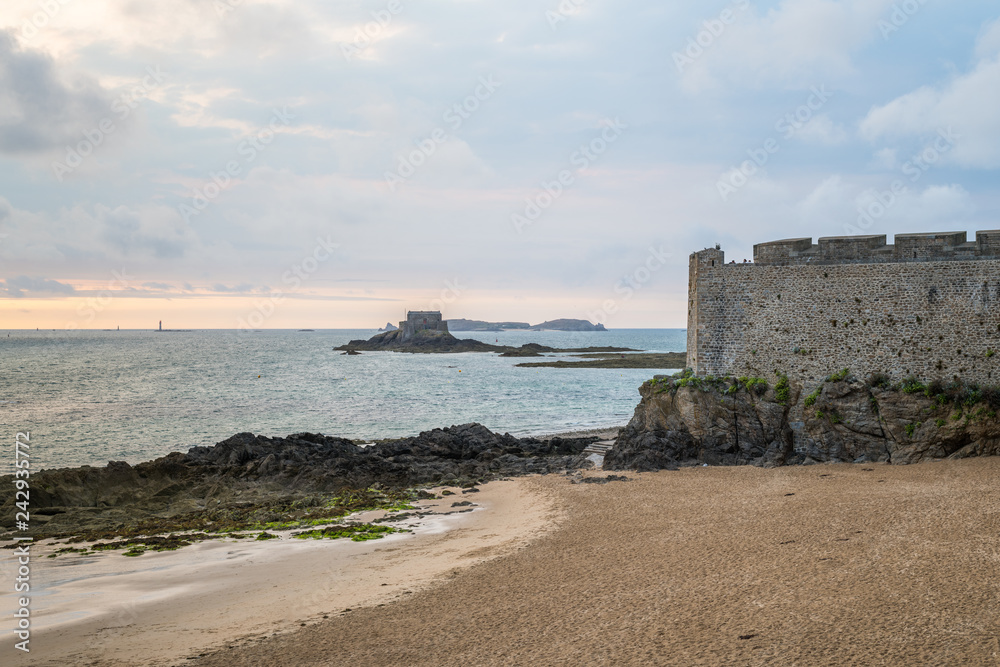 Beach, wall and fort in Saint-Malo on a cloudy day in summer
